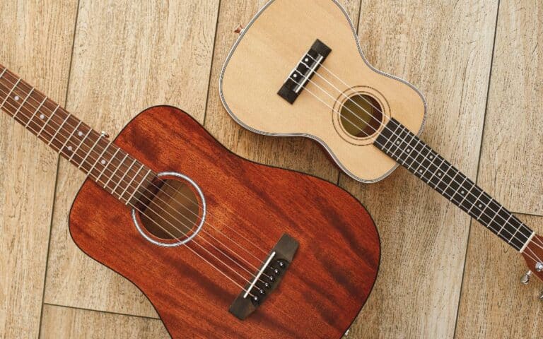 Ukulele and guitar instruments on a light wooden background